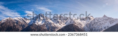 Panoramic view during sunset over snow cladded Kinner kailash mountain peaks falls in Greater Himalayas mountain range from Kalpa village, Kinnaur, Himachal Pradesh, India.