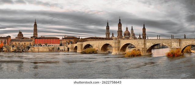 Panoramic view of the Ebro River as it flows through Zaragoza. View composed of the Stone Bridge, the Basilica of Pilar, the Cathedral of La Seo and the Archbishopric. Aragon. Spain