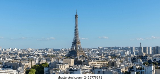 Panoramic view of the Eiffel tower, on the Parisian buildings in the center,  Arc de Triomphe de l'Étoile, located on the Charles de Gaulle square, and at the western end of the Champs Elysées avenue 