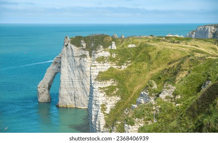 Panoramic view of elephant like sea cliff with sapphire blue sea and town in Étretat - Powered by Shutterstock