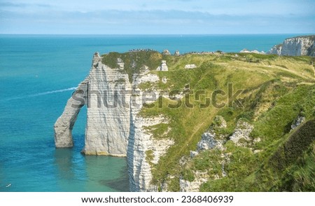Panoramic view of elephant like sea cliff with sapphire blue sea and town in Étretat