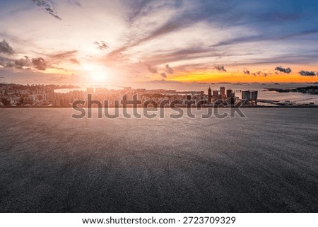 Panoramic view of an empty asphalt road and the modern city skyline at sunset.