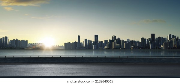Panoramic view of empty road side with city skyline. Sunset scene.