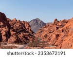 Panoramic view of endless winding empty Mouse tank road in Valley of Fire State Park through canyons of red Aztec Sandstone Rock formations and desert vegetation in Mojave desert, Overton, Nevada, USA