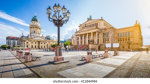 Panoramic view of famous Gendarmenmarkt square with Berlin Concert Hall and German Cathedral in golden evening light at sunset with blue sky and clouds in summer, Berlin Mitte district, Germany