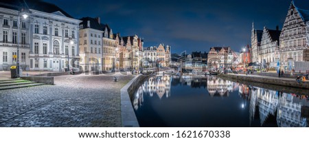 Panoramic view of famous Korenlei in the historic city center of Ghent illuminated in beautiful post sunset twilight during blue hour at dusk with Leie river, Ghent, East Flanders, Belgium
