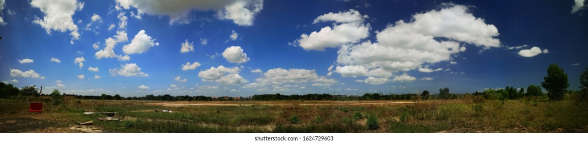 Panoramic view of fields and blue sky with clouds