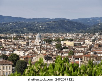 Panoramic view of Florence with historic buildings, iconic towers, and a river flowing through the city, set against a backdrop of rolling hills and a partly cloudy sky. - Powered by Shutterstock