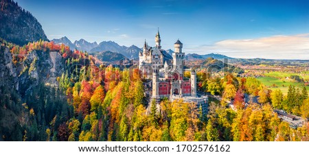 Panoramic view from flying drone of Neuschwanstein Castle, 19th-century hilltop fairytale castle. Exciting morning scene of Bavaria. Magnificent landscape of Alps, Germany, Europe.
