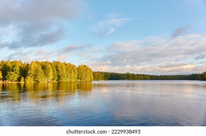 Panoramic view of the forest lake. Clear blue sky with dramatic glowing clouds after the rain. Early autumn landscape. The biggest lake in Tampere area, Nasijarvi, Finland. Nature, environment themes - Shutterstock ID 2229938493