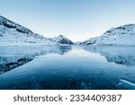 A panoramic view of a frozen lake and snowy mountains