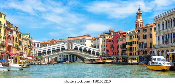 Panoramic view of Grand Canal, Venice, Italy. Rialto Bridge in the distance. It is famous landmark of Venice. Scenery of old Venice city in summer. Nice cityscape of Venice with colorful houses. 