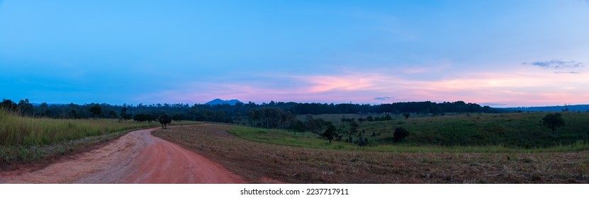 Panoramic view of gravel road in countryside with meadow at sunset - Shutterstock ID 2237717911