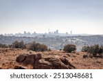 A panoramic view of the Johannesburg skyline from a hilltop, showcasing the city