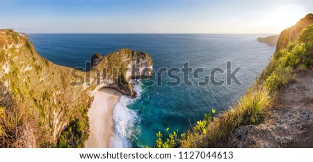 Panoramic view Karang Dawa, Manta Bay or Kelingking Beach on Nusa Penida Island, Bali, Indonesia. Tropical beach with a turquoise ocean among the rocky cliffs. Sunset on a tropical island. Travel