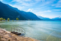 Panoramic View Of Lake Annecy And Its Mountains With A Blue Sky And Some Clouds In The Morning