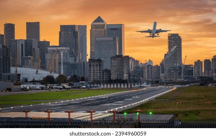 Panoramic view of the London skyline with Canary Wharf district and the runway of the City Airport in front during sunset time - Powered by Shutterstock - Get 15% off with code: PIKWIZARD15