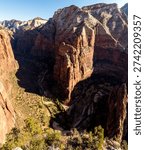 Panoramic view looking deep into Zion Canyon from a high overlook in Zion National Park, Utah, showing towering sandstone cliffs, canyon depth and the winding canyon floor.