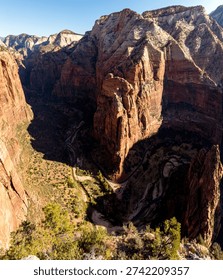 Panoramic view looking deep into Zion Canyon from a high overlook in Zion National Park, Utah, showing towering sandstone cliffs, canyon depth and the winding canyon floor.