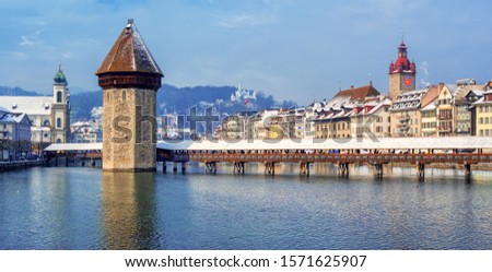 Panoramic view of Lucerne Old town, Switzerland, with wooden Chapel bridge and Reuss river, snow covered on a cold winter day