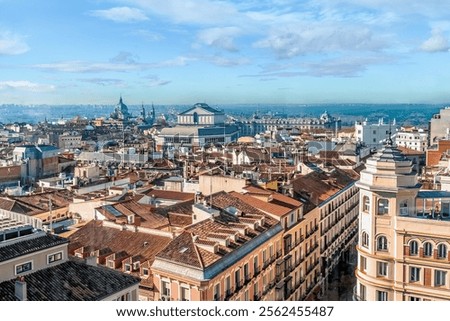 Panoramic view of Madrid rooftops, with the Teatro Real and Almudena Cathedral in the distance, Spain. Scene captures the contrast between the traditional terracotta roofs and iconic landmarks