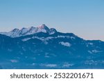 Panoramic view of majestic snow-capped mountain peak Mittagskogel (Kepa) in Karawanks seen from Rosental, Carinthia, Austria. Tranquil alpine landscape. Peaceful scene in Austrian Alps in winter