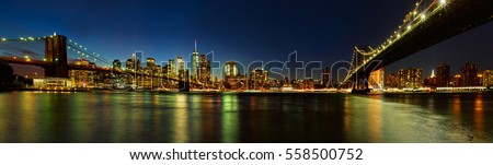 Panoramic view of Manhattan and Brooklyn Bridges from Brooklyn at night. Cityscape of New York