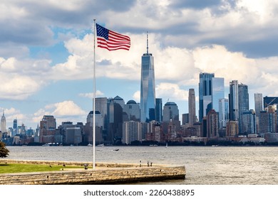 Panoramic view of Manhattan cityscape and USA flag in New York City at sunset, NY, USA