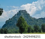 Panoramic view of medieval castle Burg Hochosterwitz build on hilltop in Sankt Georgen am Längsee, Sankt Veit an der Glan, Carinthia, Austria. Hill is surrounded by vast forest. Clouds building up