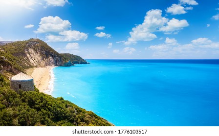 Panoramic View To Milos Beach With The Old Windmill In Front And Fluorescent Turquoise Sea On The Ionian Island Of Lefkada, Greece