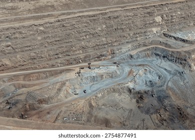Panoramic view of a mine in the process of blasting and iron ore extraction operations