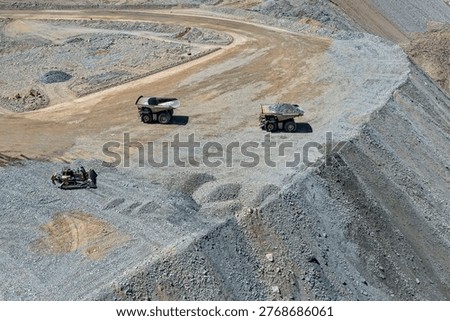 Panoramic view of mining dump trucks unloading waste material at a mine dump
