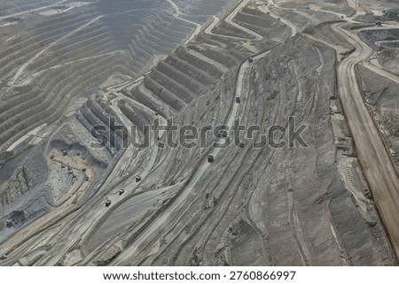 Panoramic view of mining operations involving blasting, extraction, and transport of minerals