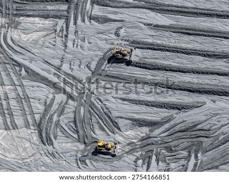 Panoramic view of a mining tailings dam with bulldozers removing sedimented material