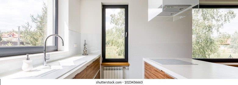 Panoramic View Of Modern Kitchen With White Countertops, Big Window And Island