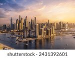 Panoramic view of the modern skyline of Dubai Marina with skyscrapers reflecting the warm sunset sunlight, United Arab Emirates