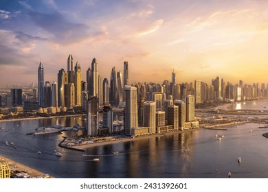 Panoramic view of the modern skyline of Dubai Marina with skyscrapers reflecting the warm sunset sunlight, United Arab Emirates