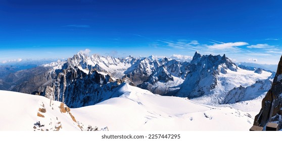 Panoramic view of Mont Blanc massif snow mountain with tiny snow climber or hiker at the ridge of the mountain - Shutterstock ID 2257447295