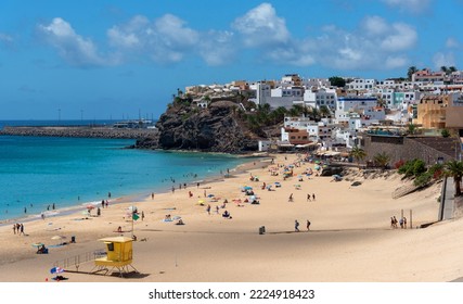 Panoramic view of the Morro Jable beach with white sand and turquoise sea full of people enjoying the sun with the village in the background the traditional architecture Fuerteventura Canary Islands