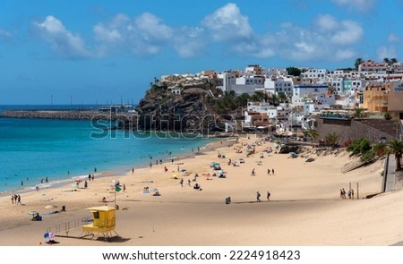Panoramic view of the Morro Jable beach with white sand and turquoise sea full of people enjoying the sun with the village in the background the traditional architecture Fuerteventura Canary Islands