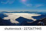 A panoramic view from mount Eisenerzer Reichenstein (2165m) near Eisenerz in Styria, Austria, Europe. Austrian Alps. The Ennstal valley is covered in clouds and fog. Hiking trail,Wanderlust. Sunny day
