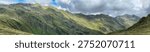 Panoramic view of a mountain range in Königsleiten Austria during the summer The landscape features green slopes and rocky peaks under a cloudy sky creating a scenic outdoor environment.