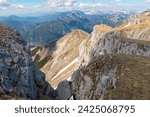 Panoramic view from mountain summit Foelzstein in wild Hochschwab massif, Styria, Austria. Looking at majestic Ennstaler Alps in Gesaeuse national park in distance. Wanderlust in remote Austrian Alps