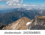 Panoramic view from mountain summit Foelzstein in wild Hochschwab massif, Styria, Austria. Looking at majestic Ennstaler Alps in Gesaeuse national park in distance. Wanderlust in remote Austrian Alps