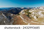 Panoramic view from mountain summit Foelzstein in wild Hochschwab massif, Styria, Austria. Looking at majestic Ennstaler Alps in Gesaeuse national park in distance. Wanderlust in remote Austrian Alps