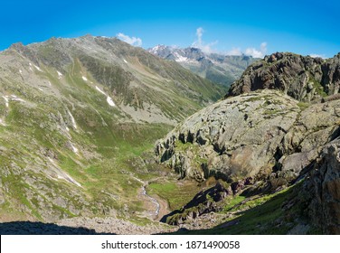 Panoramic view of mountain valley with winding stream of spring and snow-capped peaks at Stubai hiking trail, Stubai Hohenweg, Summer rocky alpine landscape of Tyrol, Stubai Alps, Austria - Powered by Shutterstock