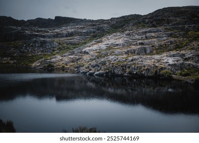 A panoramic view of the mountains and lake in Serra da Estrela, Portugal, captured in rainy weather, creating a serene and mystical landscape. - Powered by Shutterstock