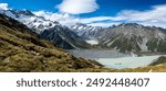 A panoramic view of Mueller Lake and Hooker Valley in AorakiMount Cook National Park, New Zealand, showcasing the turquoise lake, snow-capped peaks, and lush valley floor.