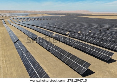 Panoramic view of multiple rows of mechanized solar panels installed in the desert