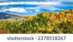 Panoramic view of New Hampshire fall foliage colors with clouds covered Mount Washington, in the background, as viewed from Bethlehem